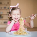 happy girl eating pasta