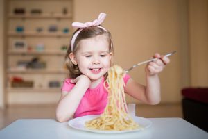 happy girl eating pasta